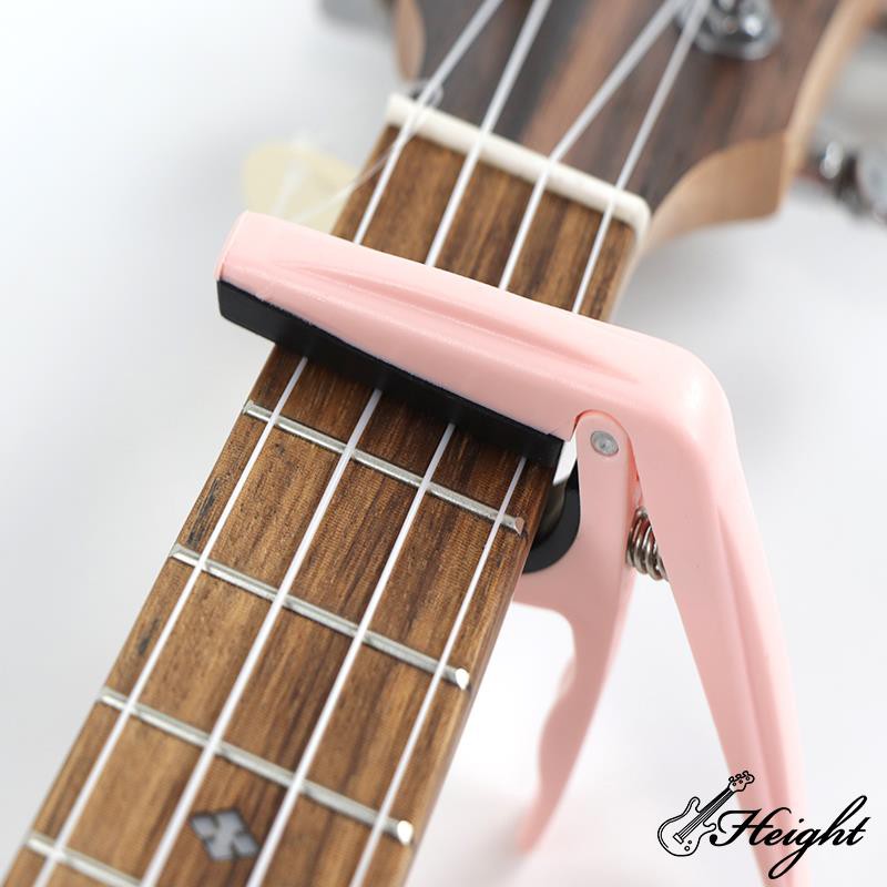 Pink capo on ukulele